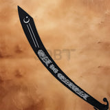 Close-up of black Arabian dragon scimitar showing floral engravings, crescent moon design and curved blade.