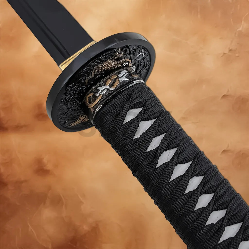 Detailed view of the black wrapped katana handle with a decorative black and gold guard.