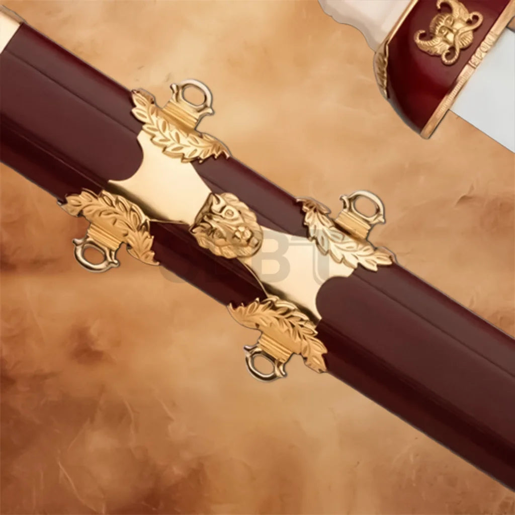 Close-up of the Gladiator Antique Sword Replica scabbard featuring ornate gold-tone fittings, decorative lion emblem, and rich burgundy finish.
