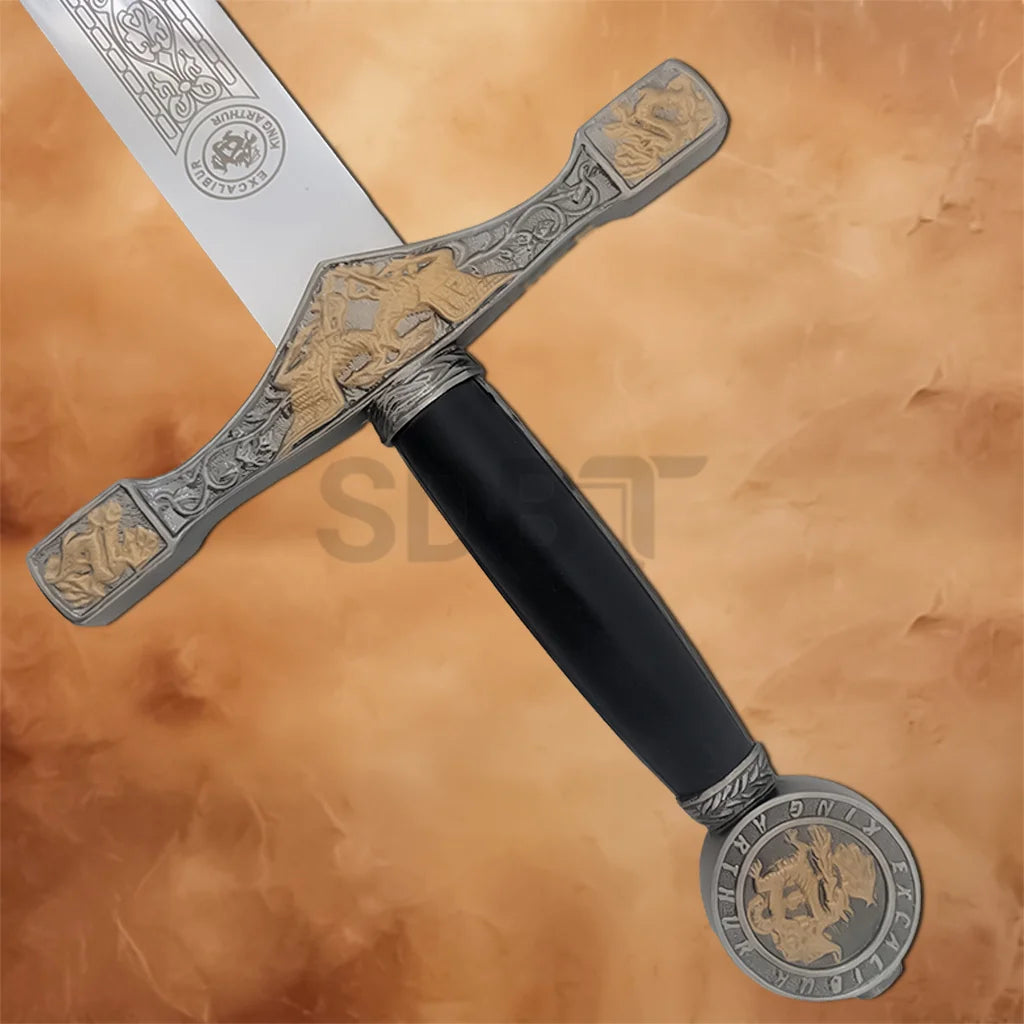 Close-up of King Arthur Excalibur sword handle with ornate crossguard, black grip and round decorative pommel.