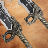 Close-up of the Kratos Blades of Chaos replica handles featuring dragon-inspired guards, engraved details, and weathered metallic finish.