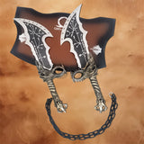 Angled view of the Kratos Blades of Chaos replica mounted on a God of War display plaque with connecting chain.