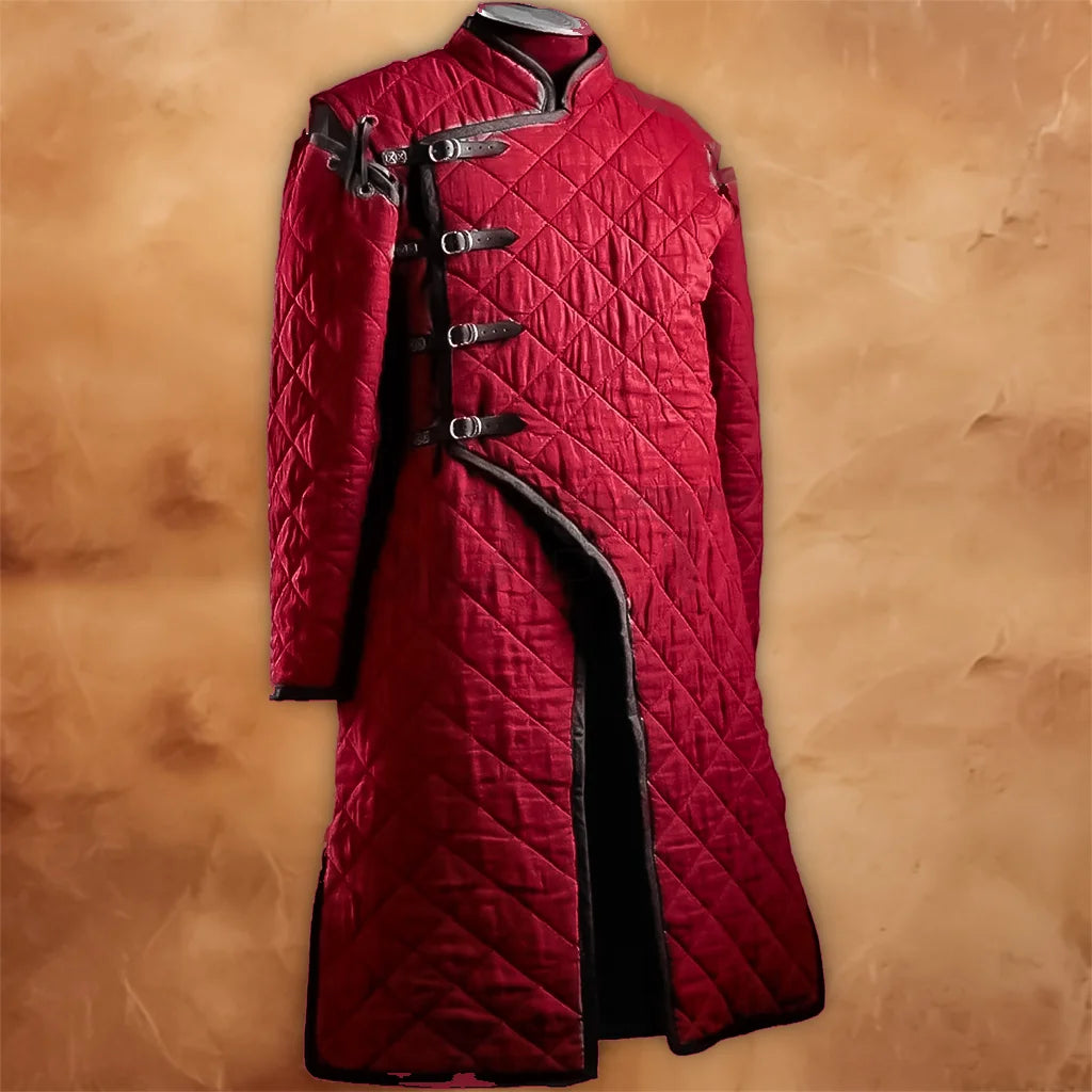 Red padded gambeson aketon medieval costume jacket displayed on a mannequin, featuring diamond quilting, long sleeves, black trim, and multiple front buckle fastenings.