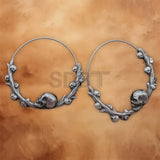 Angled view of Skull Vine hoop earrings featuring intricate vine detailing and a polished stainless steel finish.