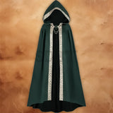 Women’s medieval hooded cloak in dark green with a black inner layer, pointed hood, flowing full-length design, and decorative gold trim.